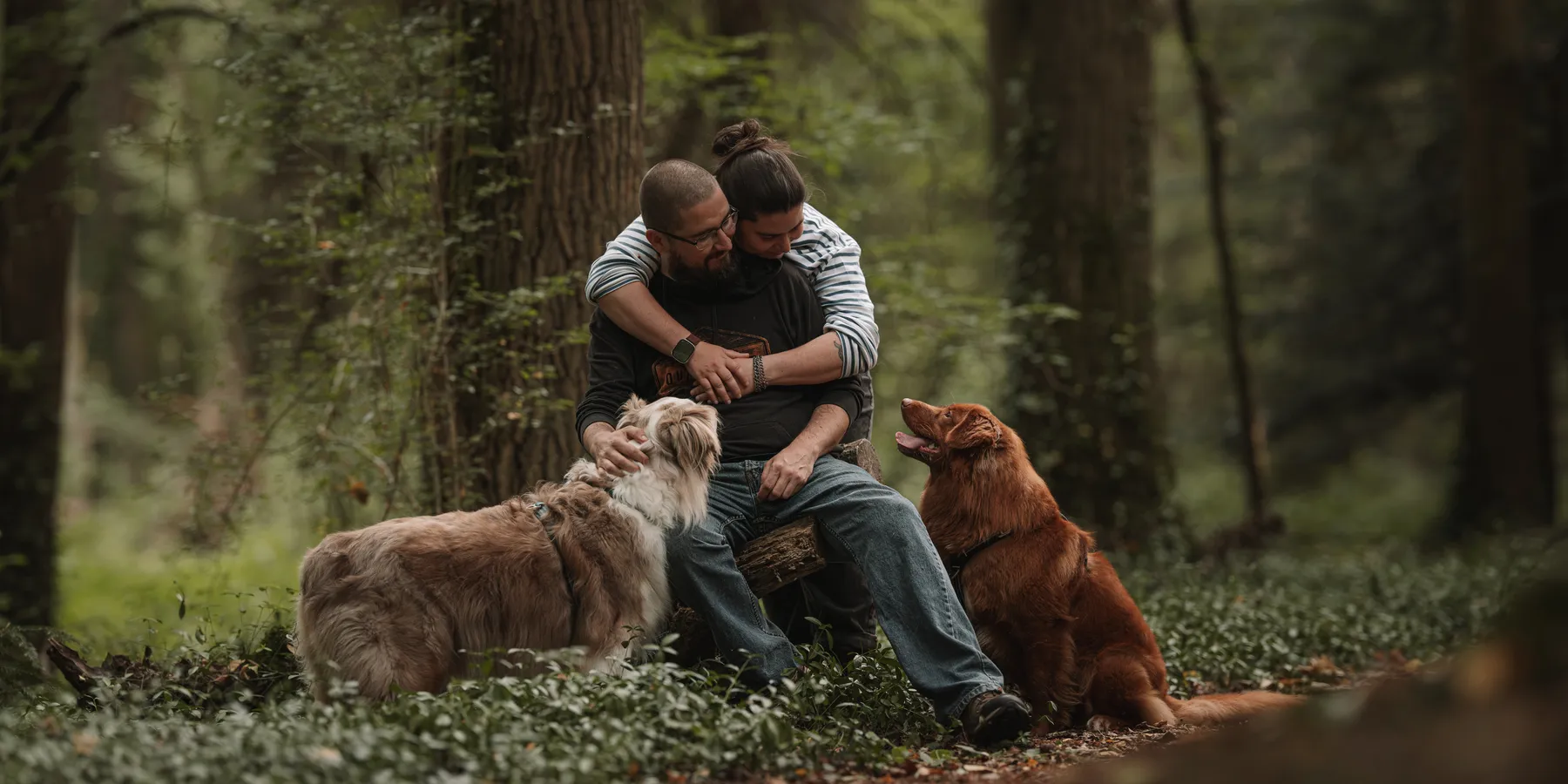 Un couple entouré de ses chiens dans la forêt